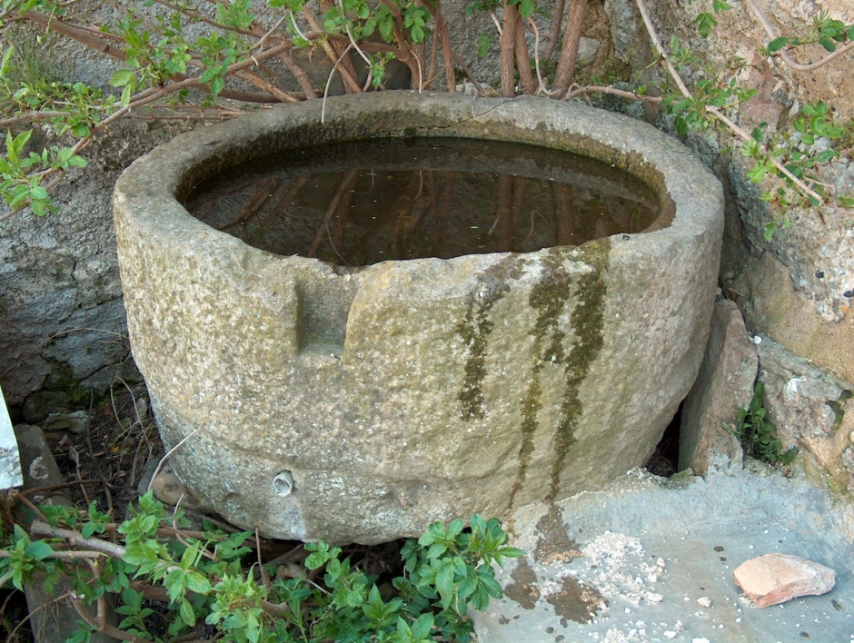 Pica baptismal d’època medieval situada a l’exterior de Sant Martí de Capolat al 2004 (SAB, 2004).