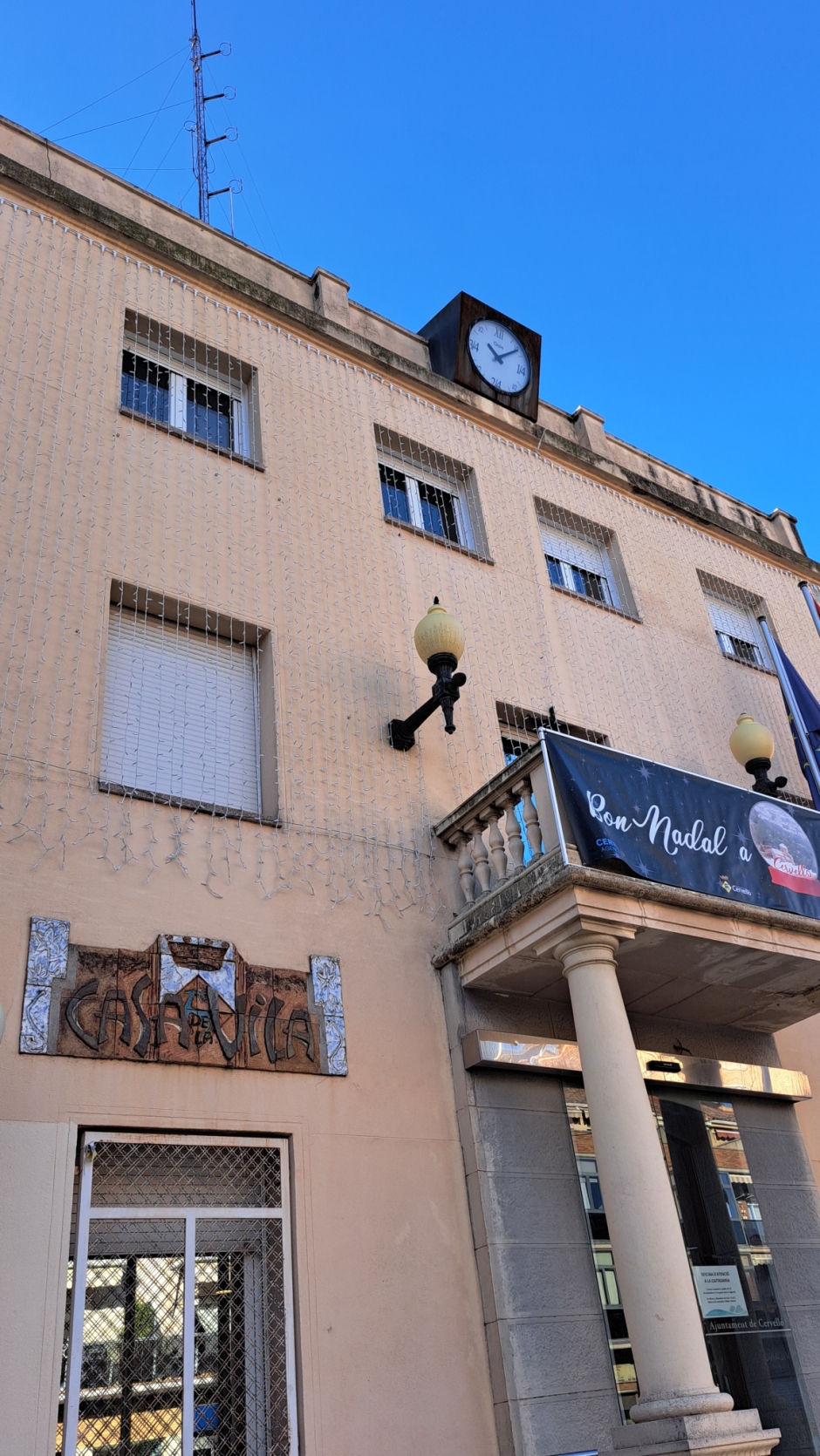 Detall de la placa i els fanals de la façana. 