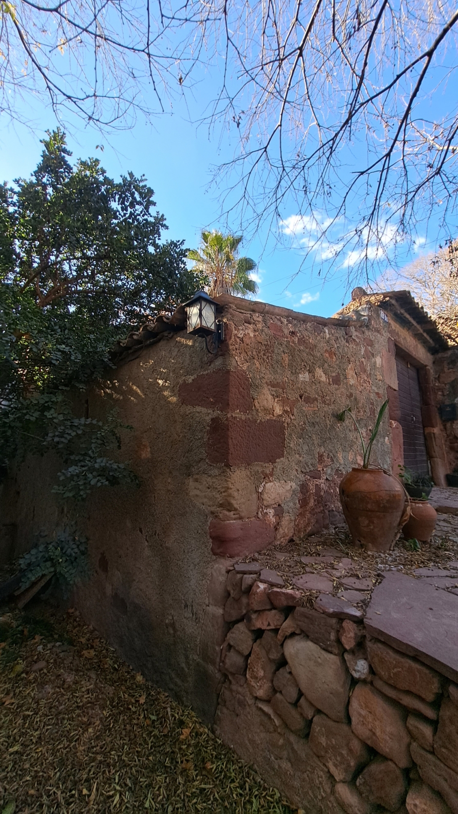 Detall del mur del barri i la porta d'accés al pati interior. 