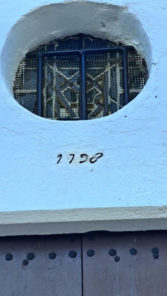 Detall de l'òcul tancat per un vitrall emplomat per sota del qual hi ha la data de construcció: 1758. 