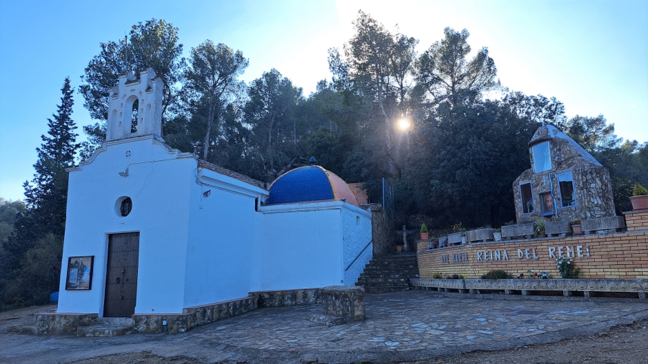 Façana est i altar exterior de pedra vista i rajola de ceràmica decorada.