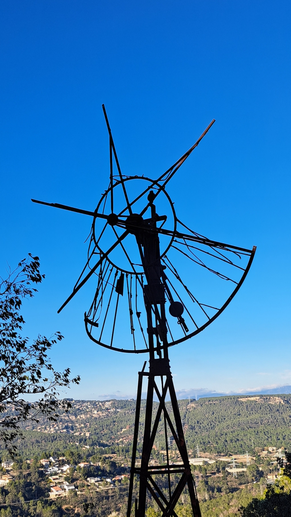 Detall del molí metàl·lic retallat a l'horitzó. Ha perdut les pales que li conferien el moviment. 