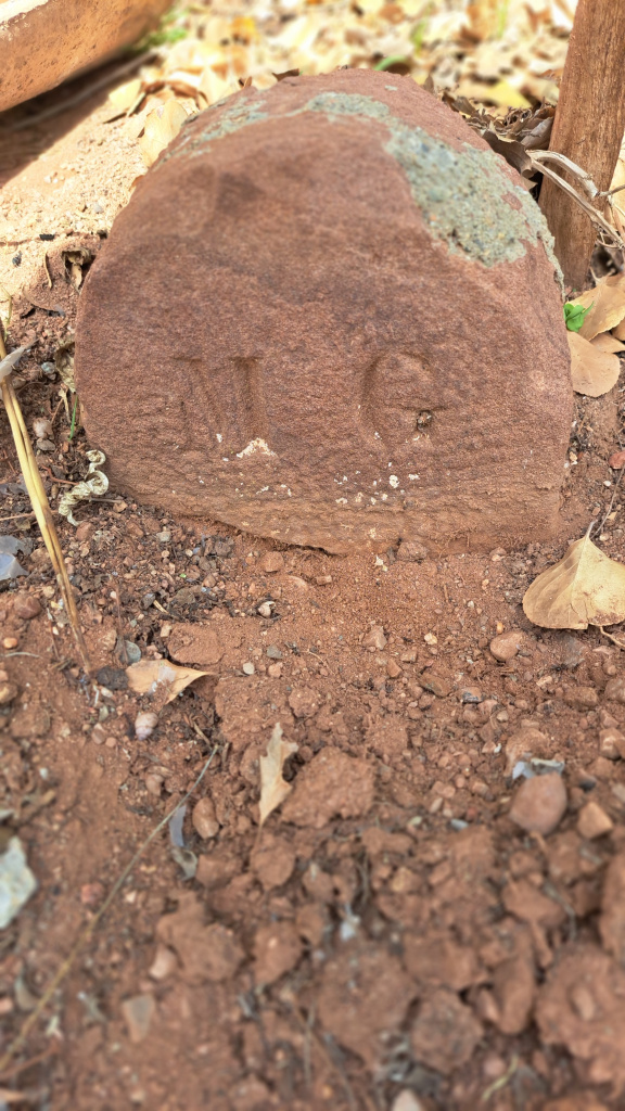 Fita amb el nom del propietari: "M.G." Manuel Gispert. Es troba aproximadament al davant de l'antiga porta de la capella, al peu del camí de la fàbrica.