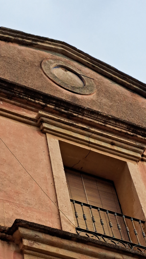 Detall del rellotge instal·lat al timpà de la façana, marcant l'eix central.