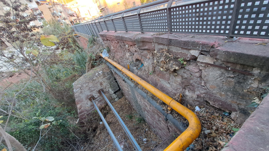 Detall constructiu dels murs, així com de l'antiga barana de pedra i l'actual de seguretat per les persones vianants. 