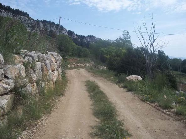 Pas amb paret lateral de protecció al camí