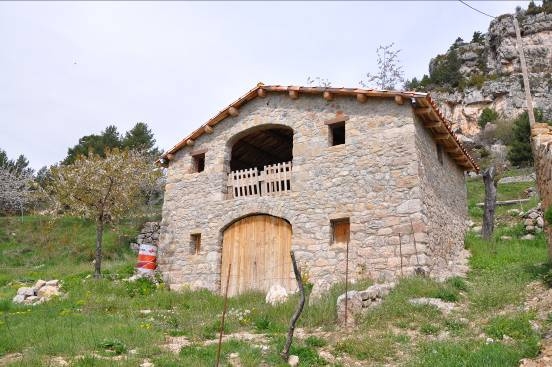 Façana principal de la masia moderna amb l'entrada i el balcó