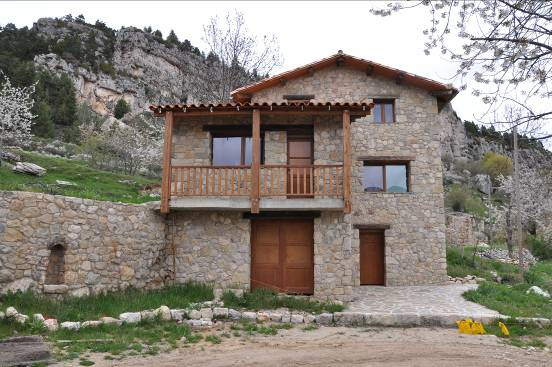 Façana principal de la casa moderna on sobresurt el balcó de fusta