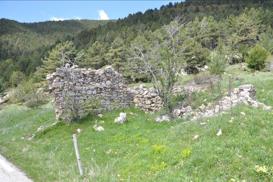 Restes del mur de l'antiga masia de Puelles
