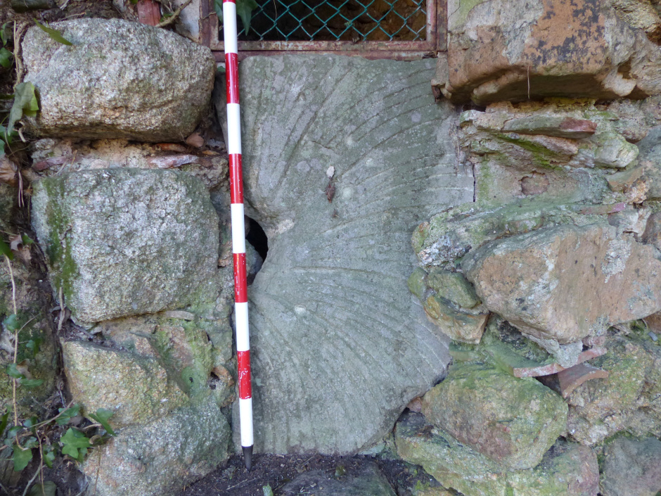 Pou de Sant Andreu de Ramió amb una pedra de molí entre ampits.