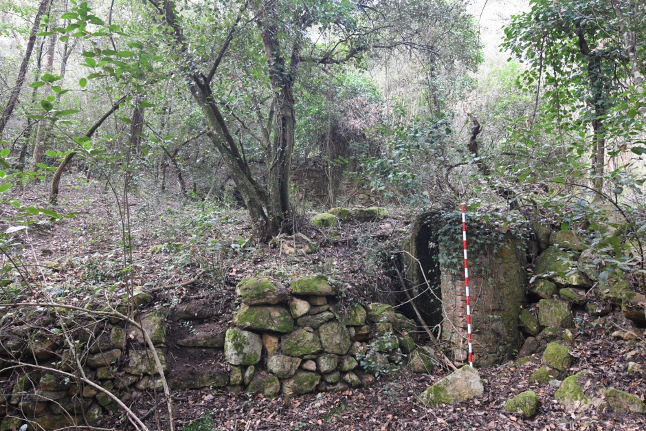 Can Grau de Baix. Muret de pedra amb graons i pou a ma dreta.