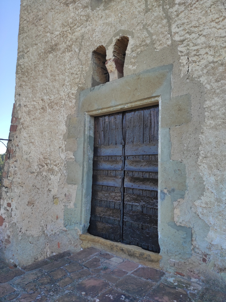 Porta segle XVII  i finestre geminada romànica, possiblement de l'edifici primigeni. 