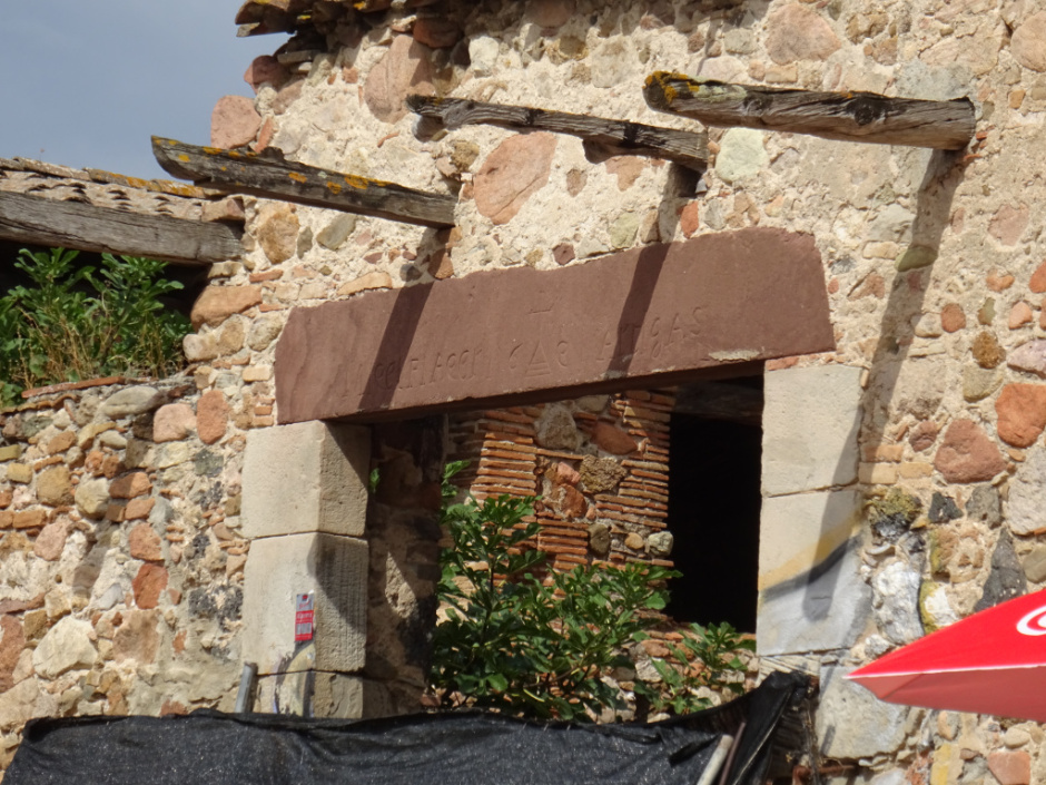 Detall de la llinda de la porta del barri de Ca l'Artigues de la Serra