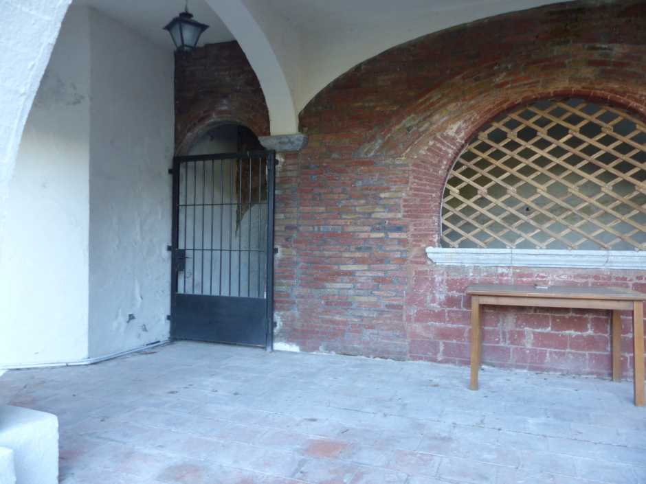 Can Torrella de Baix. Interior de la porxada amb el barriet d'accés a les restes del forn de vidre.