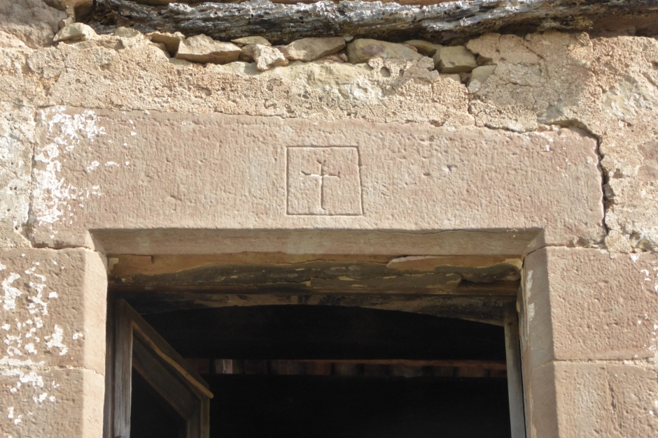 Llinda de la façana de ponent amb una creu d'astes eixamplades inscrita en un rectangle