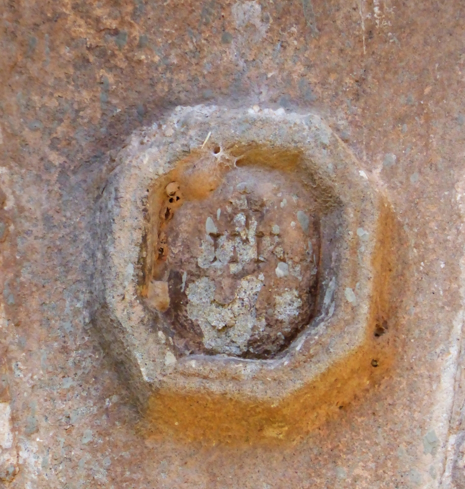 Relleu decoratiu a la dovella central del portal, amb l'emblema "IHS"