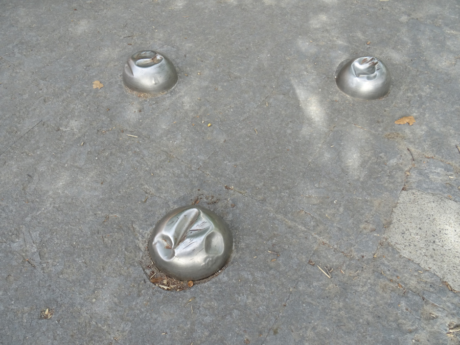 Tres mitges esferes situades al peu del monument