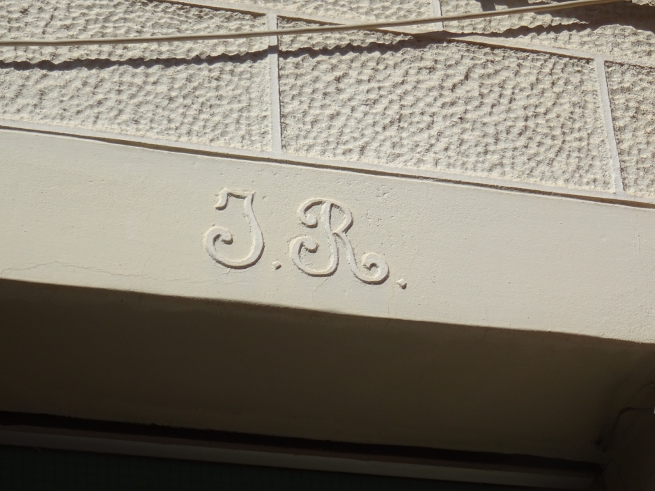 Inicials d'Isidre Ribatallada en la llinda de la porta de la casa.