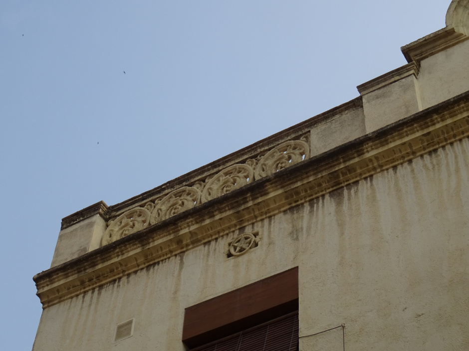 Coronament fet amb peces de morter modelat d'estil modernista de l'edifici del carrer Hospital número 5.