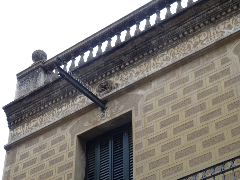 Detall decoratiu del primer pis i coronament de la façana.