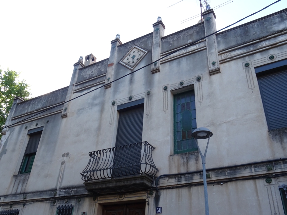 Primer pis i coronament de la casa d'Àngela Sallés (número 50).