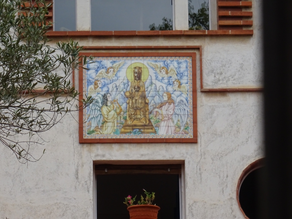 Majòlica de la Mare de Déu de Montserrat situada a la façana principal del xalet a la rambla Mn. Jacint Verdaguer número 104 - 106.