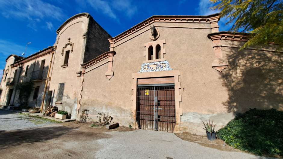 En primer plànol, l'edifici destinat a quadres.