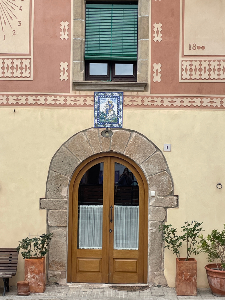 Detall de la porta adovellada amb el plafó ceràmic.