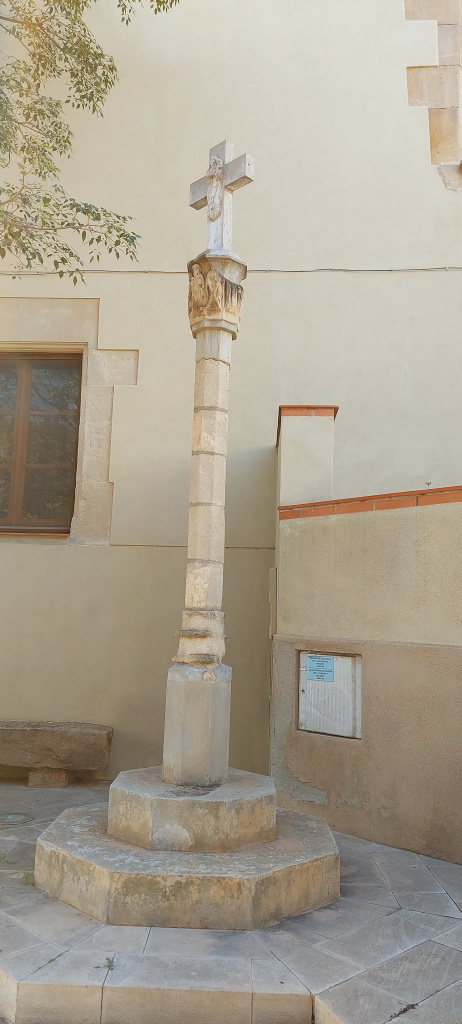 Vista general de la creu que s'erigeix a sobre d'una base de doble pedra.
