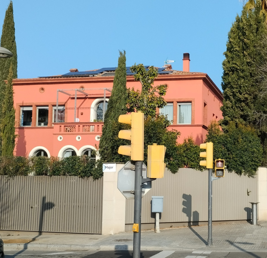 Vista detall de la façana amb la tribuna i els xiprers del jardí.