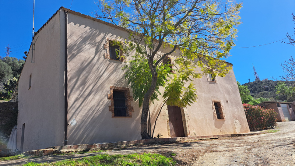 Vista de la façana principal restaurada, amb finestrals emmarcats en maó i portal en arc de pedra.