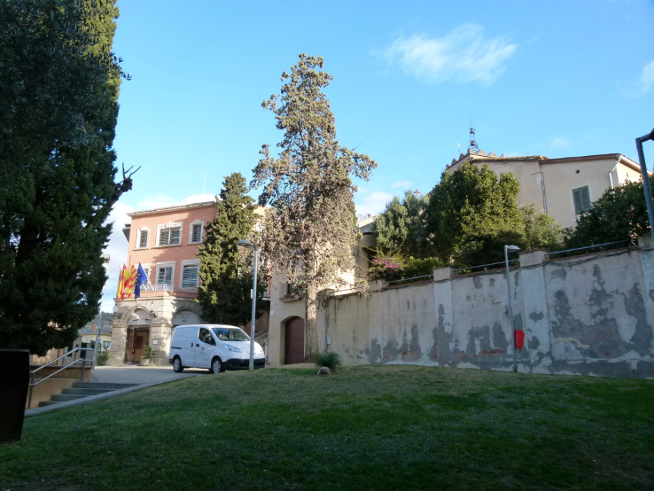 Vista de la part alta de la plaça de Jacint Verdaguer amb l'Ajuntament i el campanar de l'església al fons.