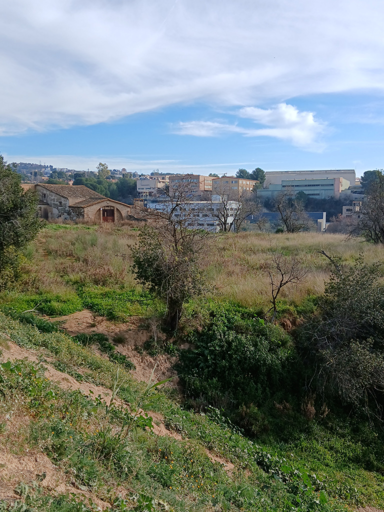 Vista de l'era de can Gelabert amb la masia al fons.