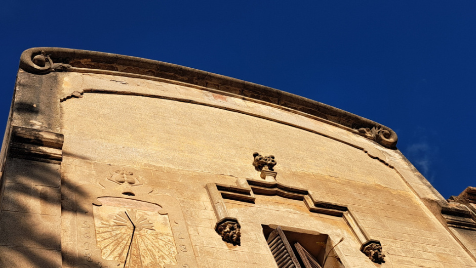 El rellotge a dreta de la finestra.