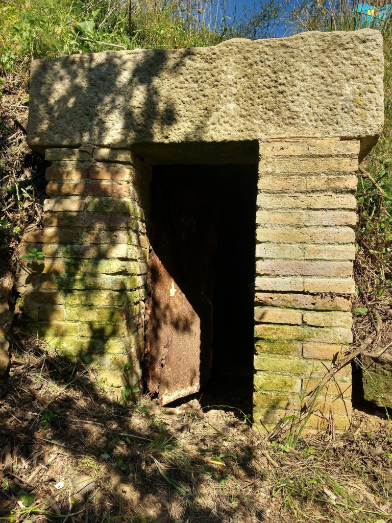 Sortida de la mina que condueix l'aigua de la gran bassa als horts situats a un nivell inferior. Està ubicada per sota de la cantonada sud-oest de la bassa. Font: Fes Fonts Fent Fonting.