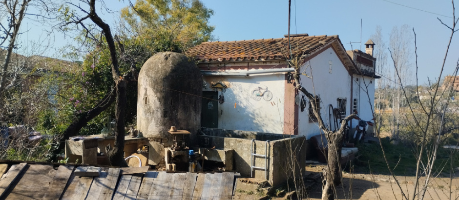 Vista general del pou i el safareig amb la casa.