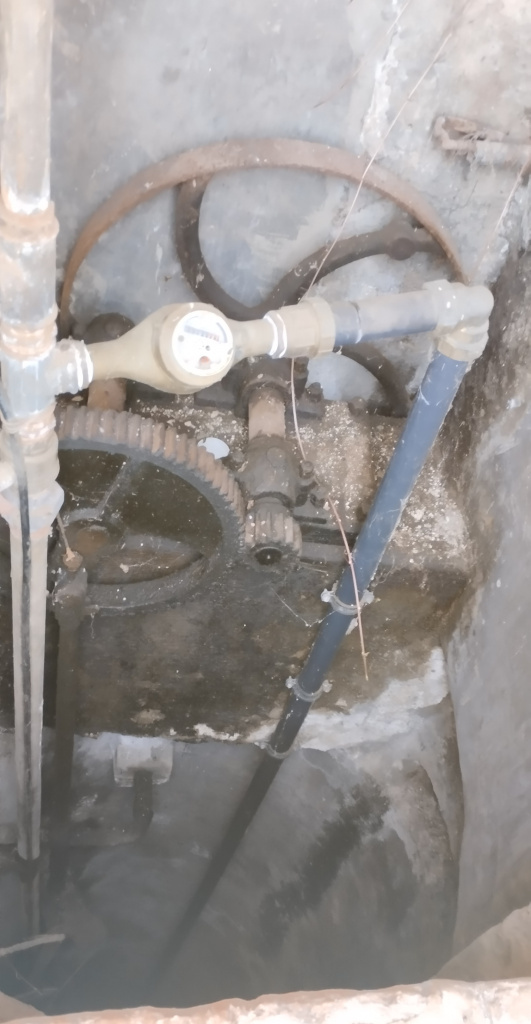 Vista de l'interior del pou amb la maquinària de la bomba d'extracció de l'aigua. 