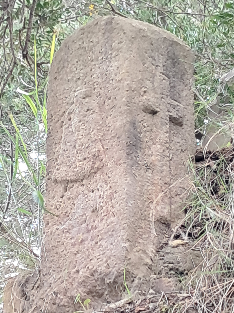 Detall de dues cares de la fita, una amb la campana de l'escut de Sant Just Desvern i l'altra, amb la creu del desaparegut terme de Santa Creu d'Olorda.