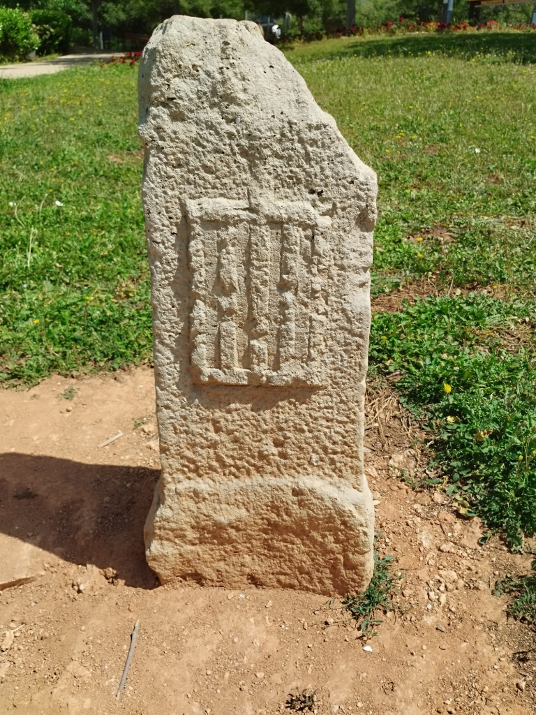 Vista frontal de la rèplica de la fita amb la imatge de la graella a la banda del terme municipal de Sant Feliu.
