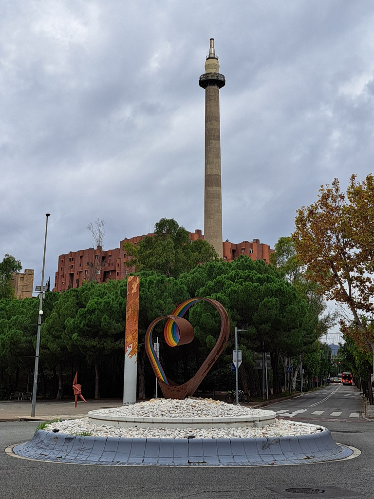 L'escultura en primer terme amb l'edifici Walden i la xemeneia de la Sanson al fons.