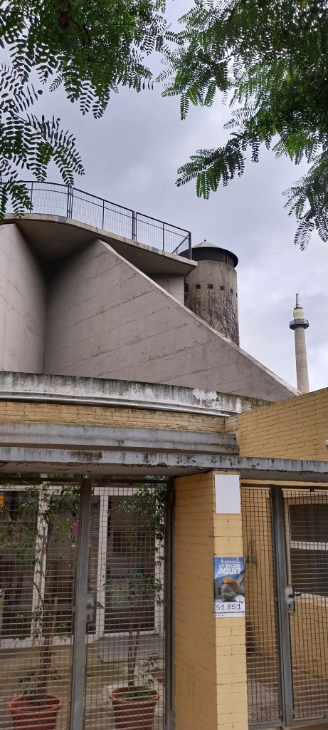 Vista de l'antic edifici industrial de l'empresa Prebetong amb la xemeneia de la Sanson al fons.