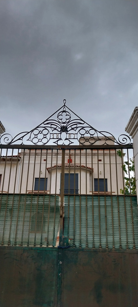 Vista detall de la porta de forja amb la data 1867.