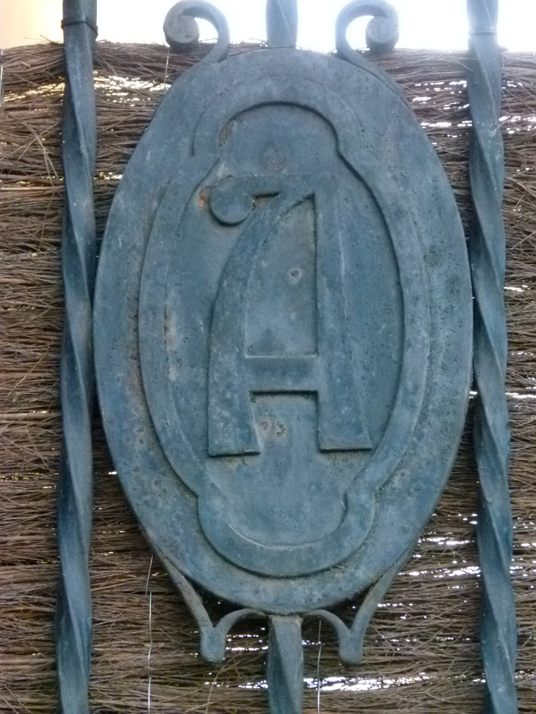 Inicial A situada a la reixa de forja d'entrada a la finca.