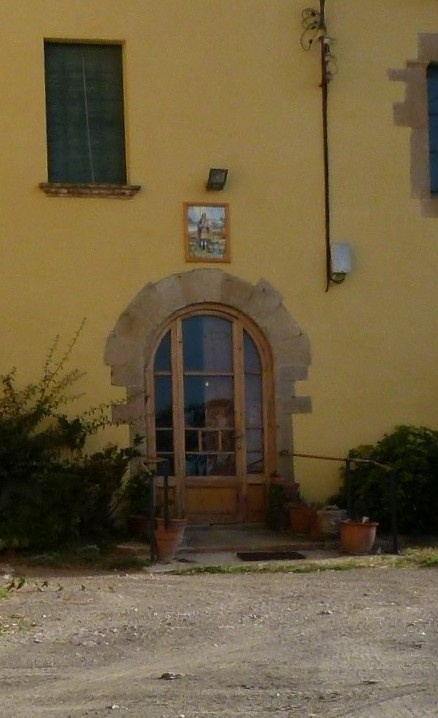 Vista detall de l'emplaçament del plafó sobre el portal d'entrada del mas.