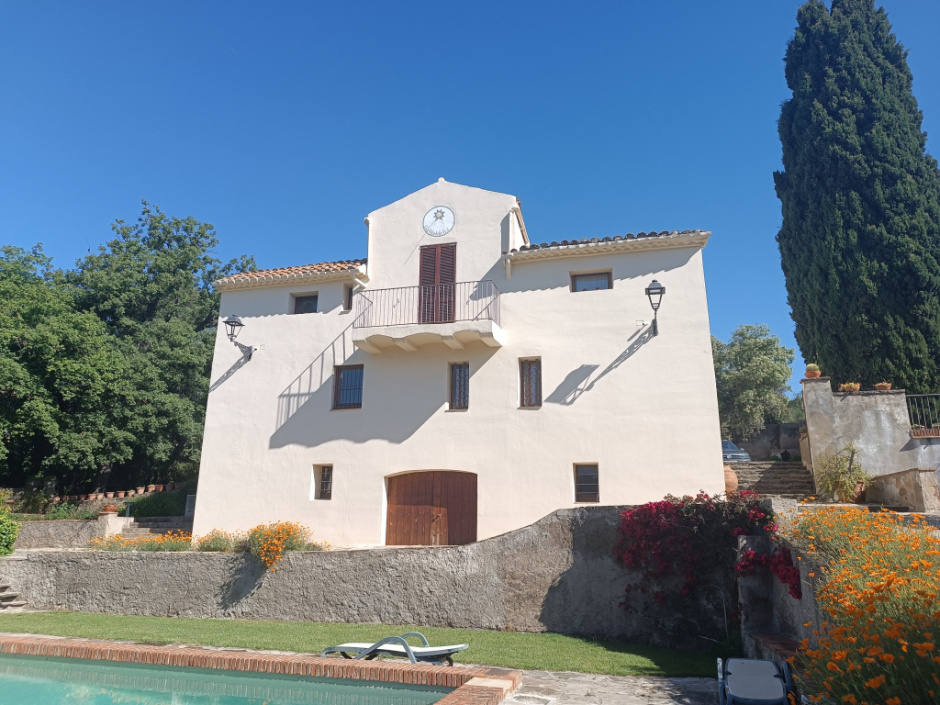 Façana sud de l'edifici de la masia, amb el rellotge de sol al capdamunt