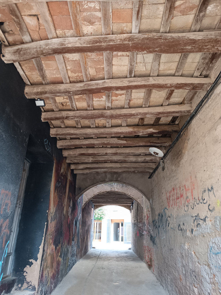 Detall de les bigues de fusta del pas cobert