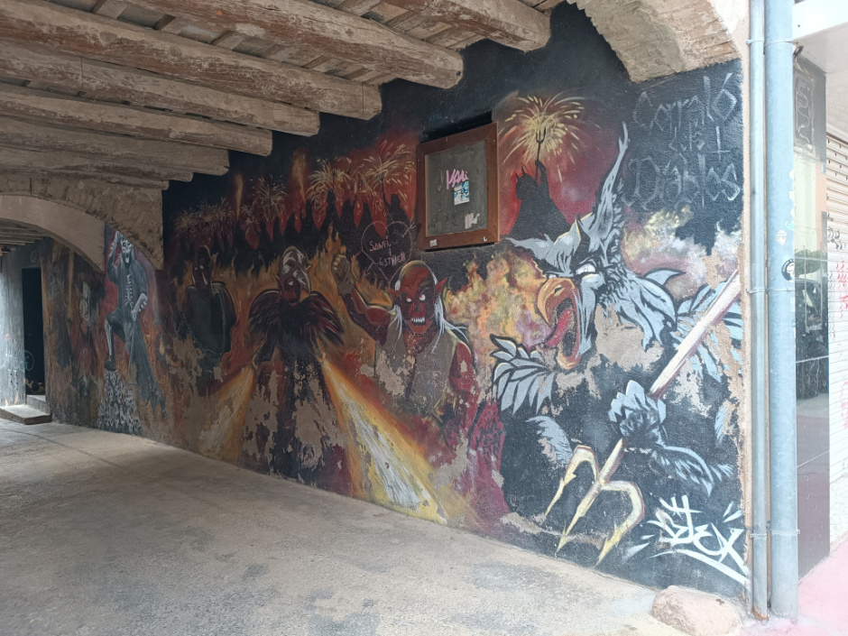 Mural de diables situat a un dels murs laterals del pas cobert