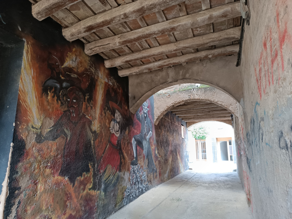 Vista general del pas cobert, amb el mural de diables a la paret de l'esquerra