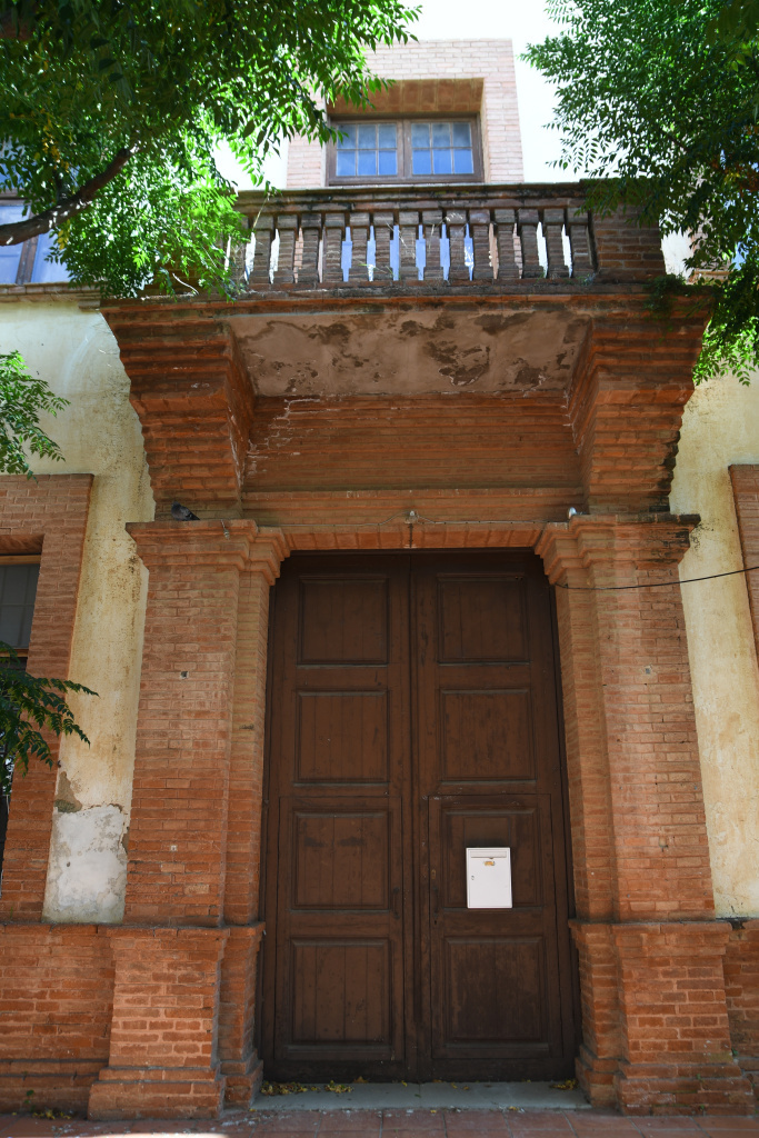 Detall del portal d'accés i el finestral amb balconera i balustrada. 