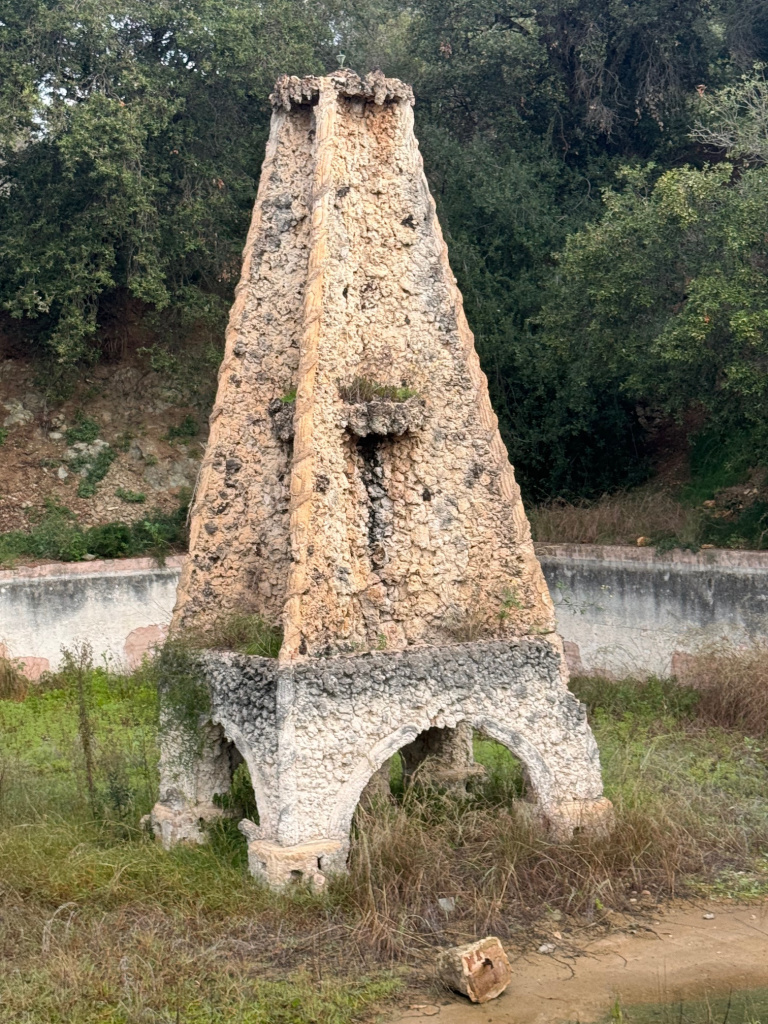 Element decoratiu amb diversos sortidors ubicat al centre de la bassa. 